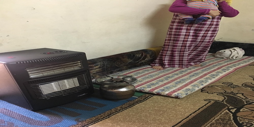 غدير تحمل طفلها في مخيم البقعة – (حفريات)
