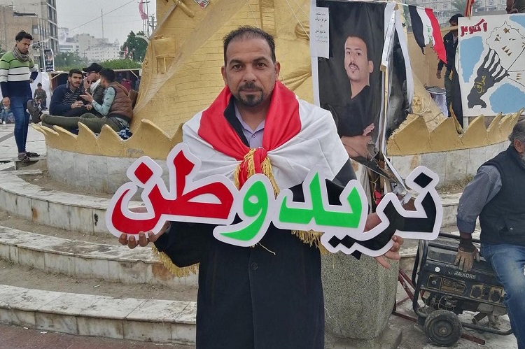 الناشط الكربلائي المغدور إيهاب الوزني يحمل شعار "نريد وطن" في احتجاجات سابقة